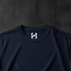 Navy blue t-shirt with a white logo on the collar against a white background