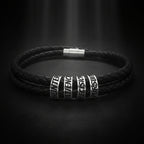 A black braided leather bracelet with silver-toned metal spacers engraved with words including HUNTER, MATHEMATICS, PRECISION, and PURSUIT.