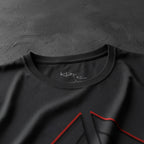 Close-up of a dark gray t-shirt with a red geometric design on a white background