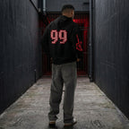 male model turning to show the back of the Gamer Hoodie, clearly displaying the large 'FINAL BOSS 99' graphic. The image emphasizes the drop shoulder and comfortable streetwear style.