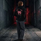 Female model turning to show the back of the Gamer Hoodie, clearly displaying the large 'FINAL BOSS 99' graphic. The image emphasizes the drop shoulder and comfortable streetwear style.