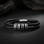 Close-up of silver stainless steel engraved beads reading HAVOC CREATE LEAVE LEGACY on double-wrap black leather bracelet